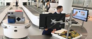 ARCHIV - 24.05.2023, Bayern, München: Zwei Mitarbeiter der Sicherheitskontrolle überprüfen in einer von insgesamt fünf neuen Anlagen am Flughafen München Gepäckstücke. Die neuen Scanner machen die Kontrolle mit moderner "3D-Technik" sicherer und schneller und für die Fluggäste deutlich bequemer. (zu dpa: «EU ebnet Weg für mehr Flüssigkeit im Flugzeug-Handgepäck») Foto: Angelika Warmuth/dpa +++ dpa-Bildfunk +++