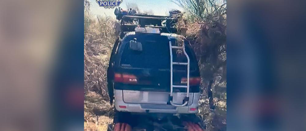 Der schwarze Mitsubishi-Van stand in dichtem Buschland mitten im Outback.