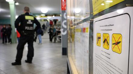 Ein Polizeibeamter steht am Bahnhof Alexanderplatz zu Beginn des Waffenverbots in Berliner U-Bahnen neben einem Hinweisschild auf das Waffenverbot. (Symbolbild)