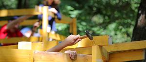 Beim Potsdamer Ferienprojekt „Stadt der Kinder“ zimmern Kinder eigene Holzhäuschen. Es fand diesmal erstmals nicht im Nuthewäldchen, sondern auf dem Gelände der Weidenhofgrundschule am Schlaatz statt.