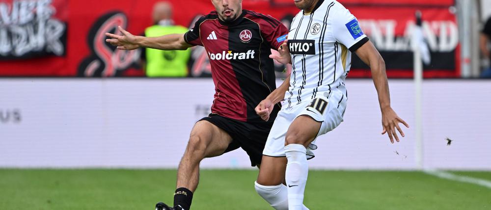 Die SV Elversberg um Jan Gyamerah (r) und der 1. FC Nürnberg um Berkay Yılmaz lieferten sich einen umkämpften Zweitliga-Auftakt.