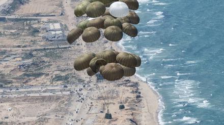 Fallschirme mit Lebensmitteln schweben nach dem Abwurf aus einer C-130 Hercules Transportmaschine über dem Gazastreifen.