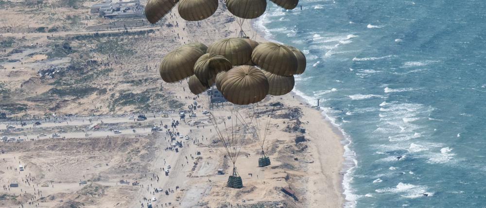 Fallschirme mit Lebensmitteln schweben nach dem Abwurf aus einer C-130 Hercules Transportmaschine über dem Gazastreifen.