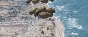 Fallschirme mit Lebensmitteln schweben nach dem Abwurf aus einer C-130 Hercules Transportmaschine über dem Gazastreifen.