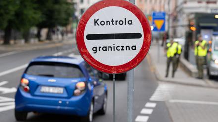 Polnische Grenzschützer stehen auf der polnischen Seite hinter der Stadtbrücke von Görlitz und beobachten den Verkehr.