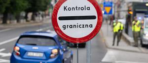 Polnische Grenzschützer stehen auf der polnischen Seite hinter der Stadtbrücke von Görlitz und beobachten den Verkehr.
