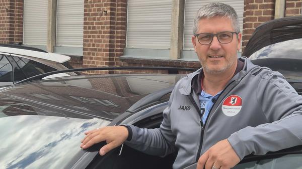 Fahrlehrer Stephan Ackerschewski steht neben einem Auto.