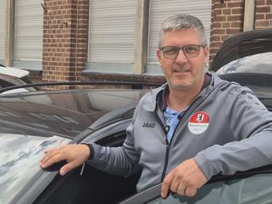 Fahrlehrer Stephan Ackerschewski steht neben einem Auto.