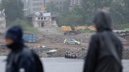 Ein Polizeifahrzeug steht auf der Baustelle an der abgerissenen Carolabrücke auf der Neustädter Elbseite.