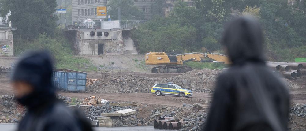 Ein Polizeifahrzeug steht auf der Baustelle an der abgerissenen Carolabrücke auf der Neustädter Elbseite.