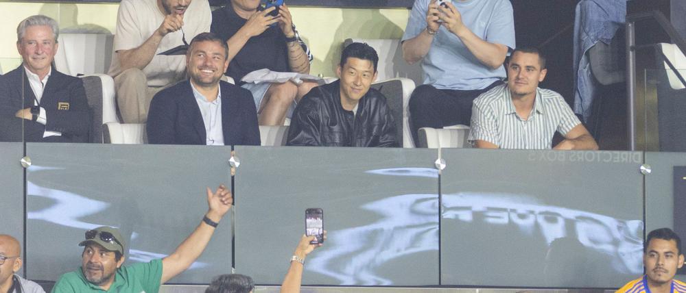 Heung-Min Son (M) verfolgt das Spiel seines neuen Clubs von der Tribüne.