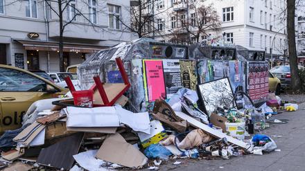 Müllcontainer mit darum liegendem Müll in Berlin-Friedrichshain.