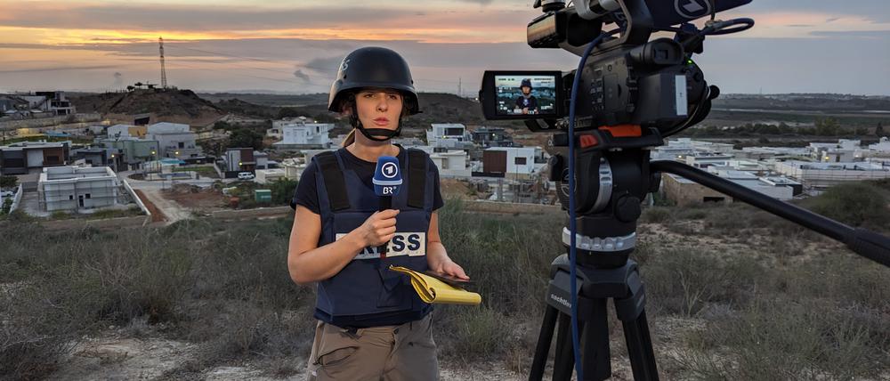 Sophie von der Tann, Korrespondentin im ARD-Studio Tel Aviv, berichtet im Oktober 2023 live aus Sderot. Einen Kilometer entfernt im Hintergrund liegt die Grenze zum Gazastreifen.