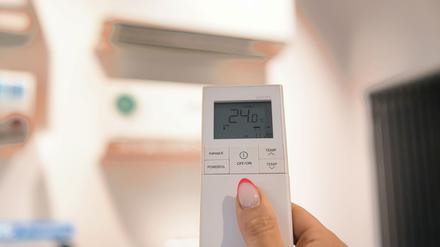 PRODUKTION - 06.08.2025, Berlin: Eine Person reguliert mithilfe einer Fernbedienung die Temperatur einer Klimaanlage auf 24 Grad Celsius im Showroom der Firma Berliner Klima Klimaanlagen Technik und Service. Bei Hitzewellen rücken Klimaanlagen auch in Deutschland zunehmend in den Fokus. Global gesehen sind solche Geräte seit Jahrzehnten auf dem Vormarsch. (zu dpa: «Skepsis gegenüber Klimaanlagen - typisch deutsch?») Foto: Paul Zinken/dpa +++ dpa-Bildfunk +++