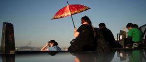 Eine Frau schützt sich an einem heißen Sommertag in Istanbul vor der Sonne.
