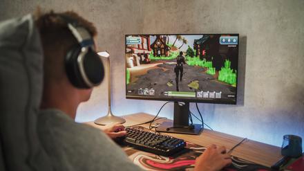 Ein Teenager spielt an einem Computer.