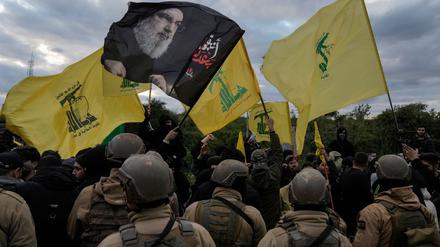 Die libanesische Armee steht Wache, während Hisbollah-Anhänger mit Fahnen der Partei und einem Bild des getöteten Hisbollah-Führers Hassan Nasrallah eine Straßenverbindung zum internationalen Flughafen blockieren.