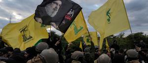 Die libanesische Armee steht Wache, während Hisbollah-Anhänger mit Fahnen der Partei und einem Bild des getöteten Hisbollah-Führers Hassan Nasrallah eine Straßenverbindung zum internationalen Flughafen blockieren.