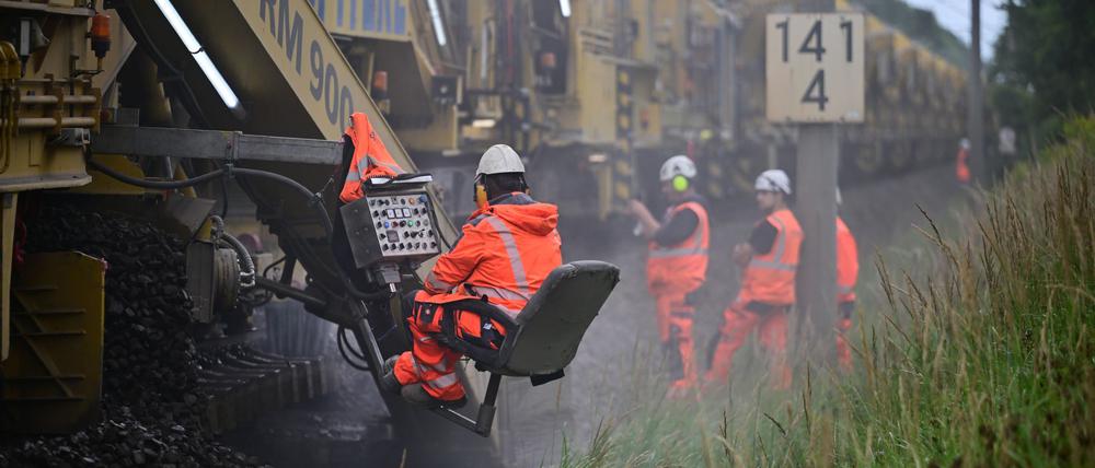 Arbeiter reinigen während der Generalsanierung der Bahnstrecke Berlin–Hamburg mit einer Bettungsreinigungsmaschine RM 900 S den Schotter unter den Gleisen.