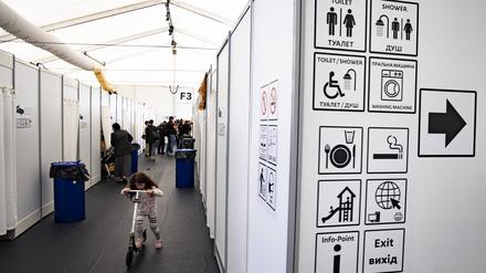 Menschen laufen in den Fluren der Zelte mit Schlafraum in der Unterkunft in Tegel