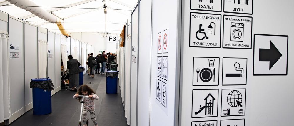 Menschen laufen in den Fluren der Zelte mit Schlafraum in der Unterkunft in Tegel