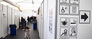 Menschen laufen in den Fluren der Zelte mit Schlafraum in der Unterkunft in Tegel