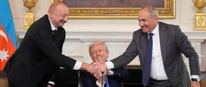 09.08.2025, USA, Washington: Präsident Donald Trump (M) schüttelt während einer trilateralen Unterzeichnung die Hände von Aserbaidschans Präsident Ilham Aliyev (l) und Armeniens Ministerpräsident Nikol Paschinjan im State Dining Room des Weißen Hauses. Foto: Mark Schiefelbein/AP/dpa +++ dpa-Bildfunk +++