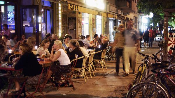 Gäste sitzen an einem Sommerabend vor dem Schwarsauer in der Kastanienallee in Berlin-Prenzlauer Berg.