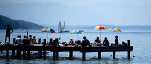 Menschen genießen das Sommerwetter am Starnberger See.