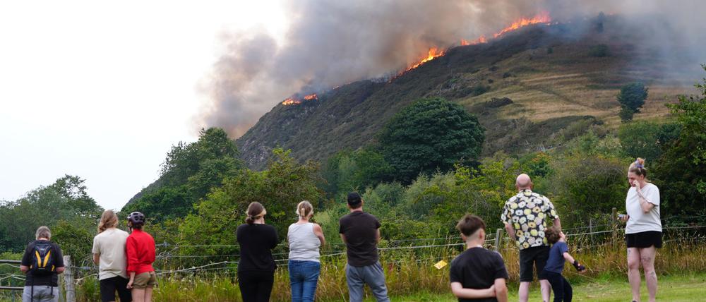Menschen beobachten das Feuer auf dem Arthur’s Seat im Holyrood Park in Edinburgh.