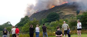 Menschen beobachten das Feuer auf dem Arthur’s Seat im Holyrood Park in Edinburgh.