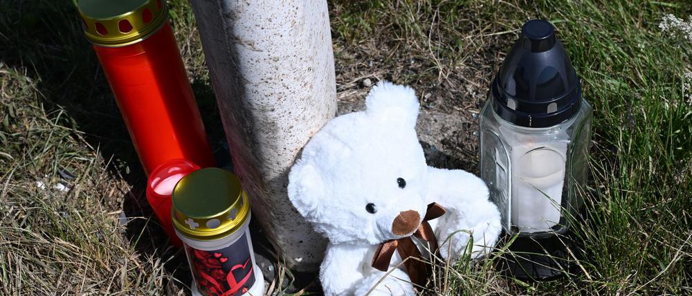 Menschen haben Kerzen und einen Teddybären an der Unfallstelle abgestellt.
