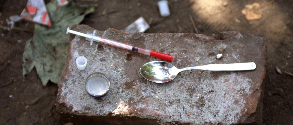 Drogenbesteck eines Fixers - Einwegspritze und Löffel wurden nach dessen Gebrauch auf einem Stein hinterlassen.