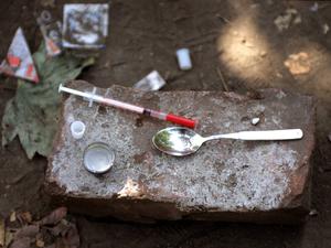 Drogenbesteck eines Fixers - Einwegspritze und Löffel wurden nach dessen Gebrauch auf einem Stein hinterlassen.
