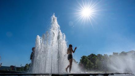 Touristen stehen im Brunnen im Lustgarten in Berlin.