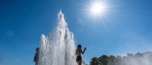 Touristen stehen im Brunnen im Lustgarten in Berlin.