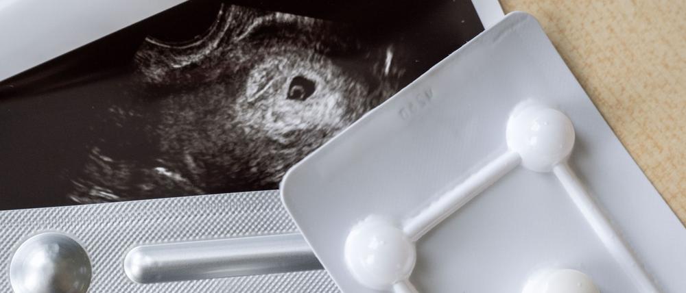 Medikamente zum Schwangerschaftsabbruch sind in einer gynäkologischen Praxis vor einem Ultraschallbild zu sehen (Symbolbild).