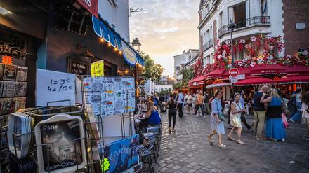 Touristen schlendern durch das Viertel Montmartre in Paris. 