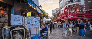 Touristen schlendern durch das Viertel Montmartre in Paris. 