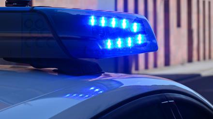 Ein Polizeifahrzeug fährt mit Blaulicht durch die Innenstadt.
