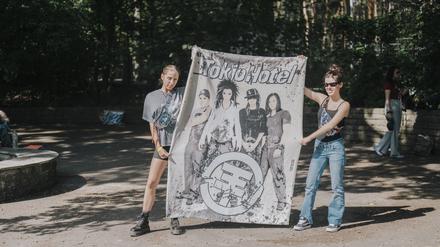 Was wäre ein Konzert ohne Transpi? Vor dem Westeingang der Parkbühne Wuhlheide warten Louanne und Charlotte auf die Band.