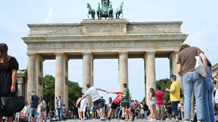 Menschen stehen vor dem Brandenburger Tor. 