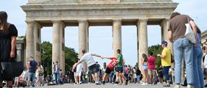 Menschen stehen vor dem Brandenburger Tor. 