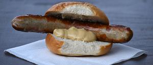 ARCHIV - 29.08.2024, Thüringen, Erfurt: Eine Thüringer Rostbratwurst mit Senf im Brötchen liegt auf einem Tisch. (zu dpa: «Kampf um die (Brat)Wurst? - Forscher finden uralte Urkunde») Foto: Martin Schutt/dpa +++ dpa-Bildfunk +++