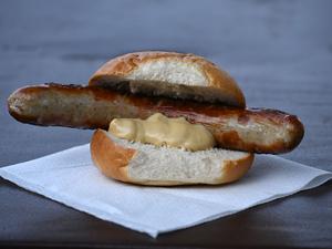 ARCHIV - 29.08.2024, Thüringen, Erfurt: Eine Thüringer Rostbratwurst mit Senf im Brötchen liegt auf einem Tisch.  (zu dpa: «Kampf um die (Brat)Wurst? - Forscher finden uralte Urkunde») Foto: Martin Schutt/dpa +++ dpa-Bildfunk +++