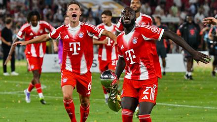 Bayerns Joshua Kimmich (li.) und Dayot Upamecano ließen sich trotz fehlender sportlicher Wichtigkeit die Freude über den ersten Titel der Saison nicht nehmen. 