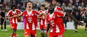Bayerns Joshua Kimmich (li.) und Dayot Upamecano ließen sich trotz fehlender sportlicher Wichtigkeit die Freude über den ersten Titel der Saison nicht nehmen. 