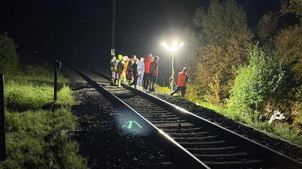 Rettungskräfte stehen an der Unglücksstelle.