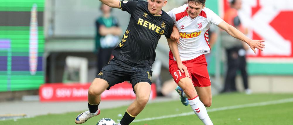 Köln-Neuzugang Isak Johannesson kämpft gegen Regensburg Leo Mätzler um den Ball.