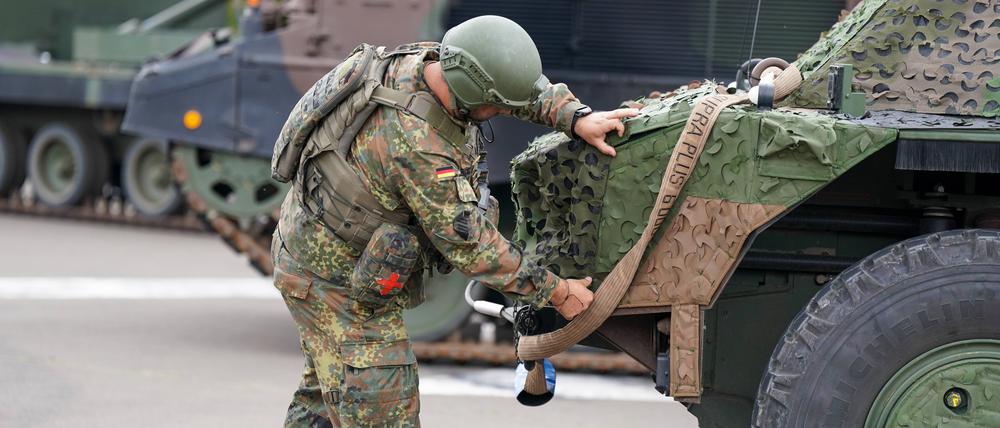  Ein Bundeswehrsoldat überprüft die Tarnung und Ausrüstung eines Spähpanzers Fennek.